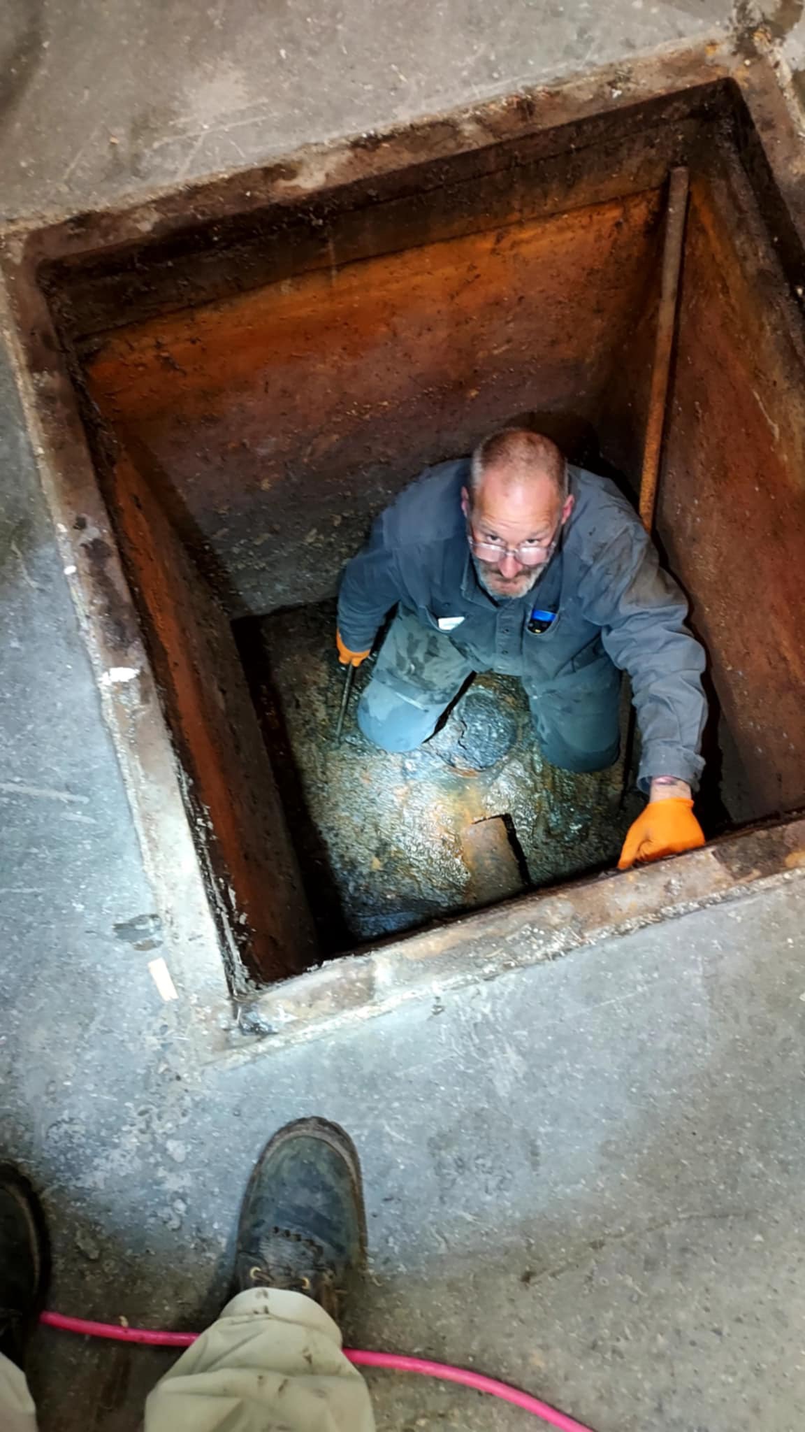 Chris working down in a drain access pit